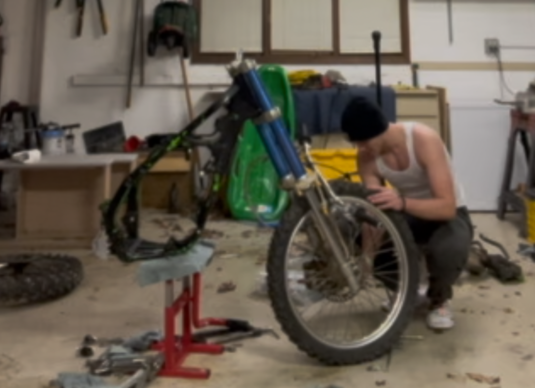 Sophomore Eli Thomas works on his dirt bike in his garage.